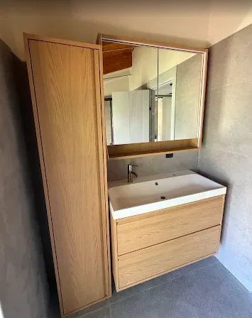 Yenilenmiş banyoda ahşap boy dolabı, aynalı dolap ve tezgah üstü lavabo